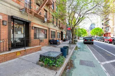 a bench on a sidewalk in front of a building at Lovely Room at 3 bedroom Apt at the heart of East Village in New York
