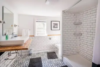 a white bathroom with a sink and a shower at Serene Catskills Retreat with Deck in Woodbourne