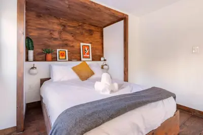 a bedroom with a large bed with a wooden wall at Serene Catskills Retreat with Deck in Woodbourne