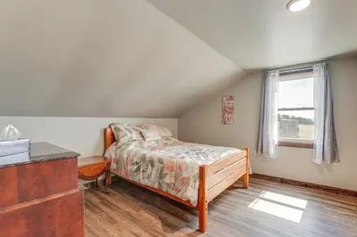 a bedroom with a bed and a dresser and a window at Wellsboro Farmhouse with Grill and Fire Pit! in Wellsboro