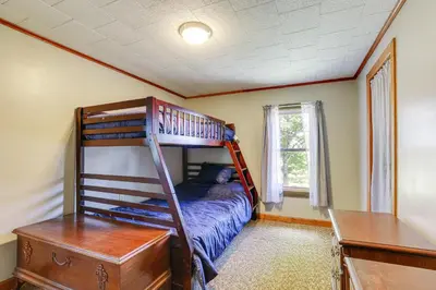 a bedroom with a bunk bed and a desk at Wellsboro Farmhouse with Grill and Fire Pit! in Wellsboro