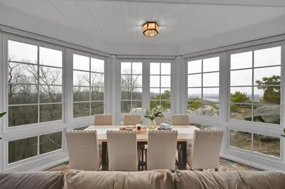 a dining room with a table and chairs and windows at Roundtop Mansion-Breathtaking View, indoor Pool in Wrightsville