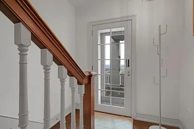 a staircase with a glass door leading to a balcony at Roundtop Mansion-Breathtaking View, indoor Pool in Wrightsville