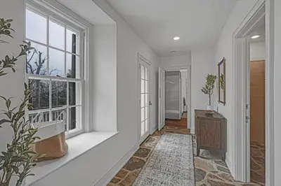 a hallway with white walls and windows and a rug at Roundtop Mansion-Breathtaking View, indoor Pool in Wrightsville