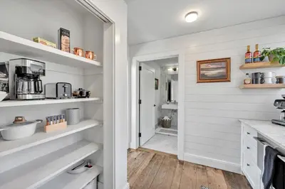 a kitchen with white walls and white shelves at The Roundtop Chalet romantic couples getaway in Wrightsville