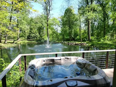 a bath tub sitting on a deck next to a pond at The Roundtop Chalet romantic couples getaway in Wrightsville