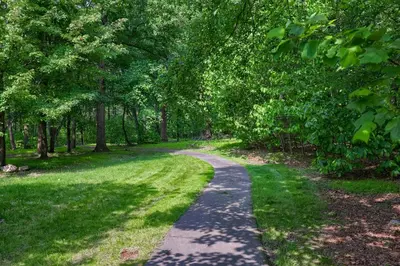 a path through a park with trees and grass at Pool Cottage at Roundtop Estate couples oasis in Wrightsville