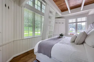 a white bedroom with a large bed and windows at Pool Cottage at Roundtop Estate couples oasis in Wrightsville