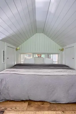 a large bed in a white room with a window at Pool Cottage at Roundtop Estate couples oasis in Wrightsville