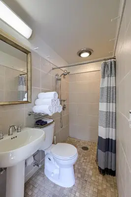 a bathroom with a white toilet and a sink at Pool Cottage at Roundtop Estate couples oasis in Wrightsville