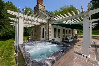 an outdoor hot tub under a pergola at Pool Cottage at Roundtop Estate couples oasis in Wrightsville