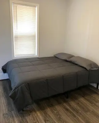a large bed in a room with a window at Private 2-bedroom apartment, free parking, direct bus to NYC Manhattan only 2 blocks away, MetLife Stadium FIFA World Cup 25 minutes away in Linden