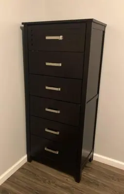 a black dresser in a corner of a room at Private 2-bedroom apartment, free parking, direct bus to NYC Manhattan only 2 blocks away, MetLife Stadium FIFA World Cup 25 minutes away in Linden