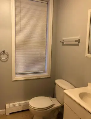 a bathroom with a toilet and a sink and a window at Private 2-bedroom apartment, free parking, direct bus to NYC Manhattan only 2 blocks away, MetLife Stadium FIFA World Cup 25 minutes away in Linden