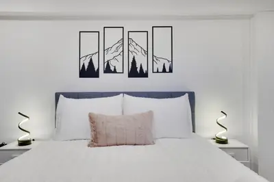 a bedroom with a bed with three paintings on the wall at (NEW) Blue Mtn Poconos Retreat Htd pool pet frndly in Effort