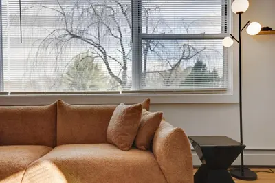 a couch in a living room with two windows at (NEW) Blue Mtn Poconos Retreat Htd pool pet frndly in Effort