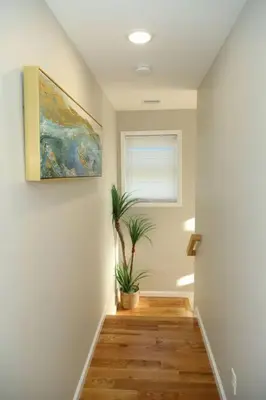 a hallway with a painting and a potted plant at Grace Filled Apartment in Newark in Newark