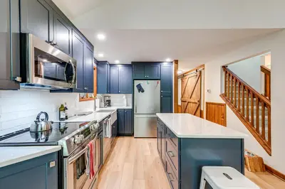 a kitchen with blue cabinets and white appliances at Creek Access and Deck Family Pocono Pines Cottage in Pocono Pines