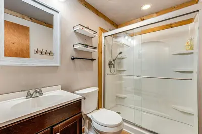 a bathroom with a shower and a toilet and a sink at Creek Access and Deck Family Pocono Pines Cottage in Pocono Pines