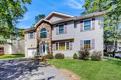 a bedroom home with a stone facade at Pocono Waterside Escape in Tobyhanna