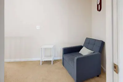 a living room with a blue chair and a table at Pocono Waterside Escape in Tobyhanna