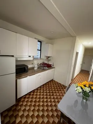 a kitchen with white cabinets and a table with flowers at Hudson Yard 408 in New York