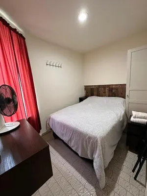 a bedroom with a bed and a desk and a red curtain at Hudson Yard 408 in New York