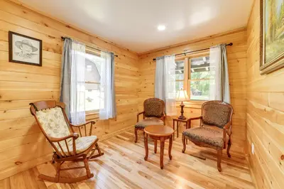 a room with chairs and a table in a log cabin at Creekside Cabin in Bainbridge with Wraparound Deck! in Sidney