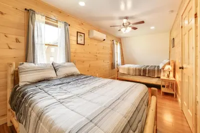 a bedroom with a bed and a ceiling fan at Creekside Cabin in Bainbridge with Wraparound Deck! in Sidney