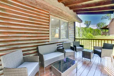 a patio with chairs and a table on a deck at Creekside Cabin in Bainbridge with Wraparound Deck! in Sidney
