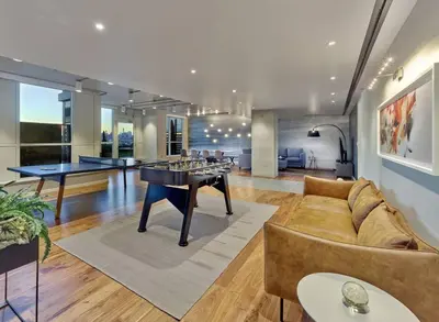 a living room with a couch and ping pong tables at Empire State View - Luxury Apt - Shuttle to NYC in Hoboken