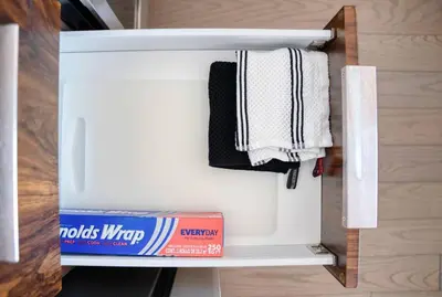 a small white refrigerator with a box and towels at Empire State View - Luxury Apt - Shuttle to NYC in Hoboken