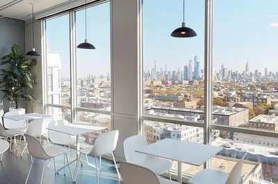 a room with tables and white chairs and a large window at Empire State View - Luxury Apt - Shuttle to NYC in Hoboken