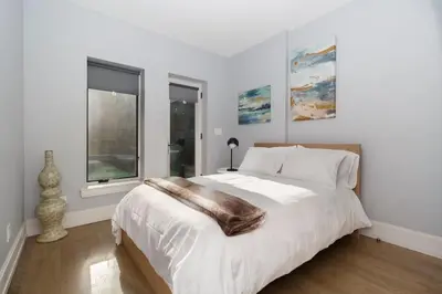 a white bedroom with a large bed with a wooden floor at Park South Central 3 Bedroom with Private Terrace in New York