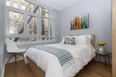a bedroom with a bed and a chair and windows at Park South Central 3 Bedroom with Private Terrace in New York
