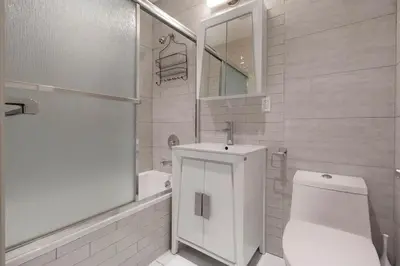 a white bathroom with a toilet and a sink at Park South Central 3 Bedroom with Private Terrace in New York