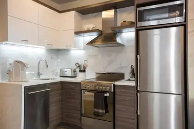 a kitchen with a stainless steel refrigerator and a stove at Park South Central 3 Bedroom with Private Terrace in New York