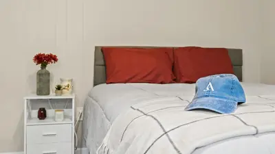 a bed with a baseball cap on top of it at Walk to the Lake Firepit and Sunroom Tomhickon in Arrowhead Lake