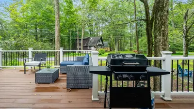 a barbecue on a deck with a grill and a couch at Walk to the Lake Firepit and Sunroom Tomhickon in Arrowhead Lake
