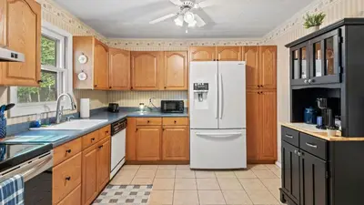 a kitchen with wooden cabinets and a white refrigerator at Walk to the Lake Firepit and Sunroom Tomhickon in Arrowhead Lake