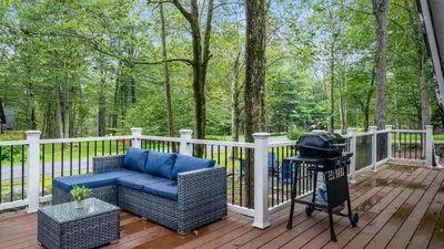 a porch with a chair and a grill on a deck at Walk to the Lake Firepit and Sunroom Tomhickon in Arrowhead Lake