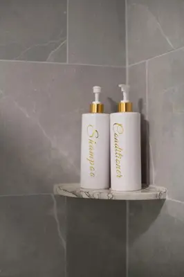 two bottles ofodorizers sitting on a shelf in a bathroom at 25 mins to Midtown Manhattan in Guttenberg