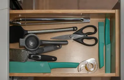 a wooden drawer with scissors and other kitchen utensils at 25 mins to Midtown Manhattan in Guttenberg