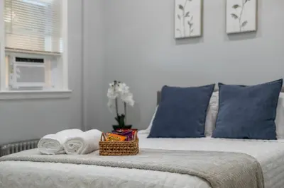 a bed with towels and a basket on top of it at 25 mins to Midtown Manhattan in Guttenberg