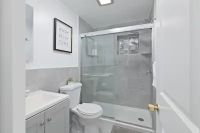 a bathroom with a toilet and a glass shower at 25 mins to Midtown Manhattan in Guttenberg