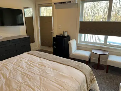 a bedroom with a bed and a chair and a television at Four Seasons For Fun Bed & Breakfast in Lakeville