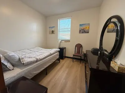 a bedroom with a bed and a mirror and a desk at Sunny Home in Sunbury