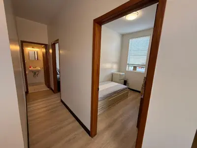 a mirror in a room with a bed and a bathroom at Sunny Home in Sunbury
