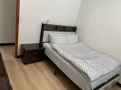 a bed in a room with a nightstand next to it at Sunny Home in Sunbury