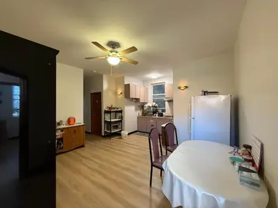 a kitchen and dining room with a table and a refrigerator at Sunny Home in Sunbury